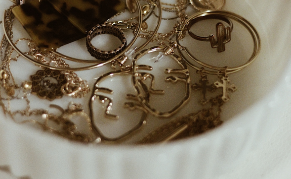 Gold jewellery in a small white bowl